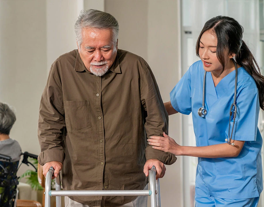 Elderly man using a walker being assisted by nurse