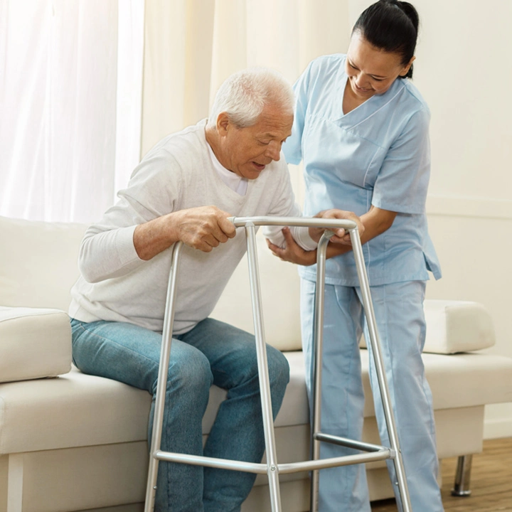 Nurse helping elderly senior man with walker